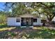 Charming single-story home features a screened-in front porch and mature trees at 6925 3Rd St, Mulberry, FL 33860