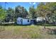 Cute single story home with mature trees, a screened porch, and a front lawn at 6925 3Rd St, Mulberry, FL 33860