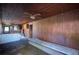 A spacious living room featuring wood paneling, ceiling fans, and kitchen access at 6925 3Rd St, Mulberry, FL 33860