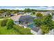 Aerial view of a home with a screened-in pool, solar panels, shed, and lush green yard at 716 Maderia Ct, Kissimmee, FL 34758