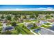 An aerial view of a neighborhood with numerous homes featuring solar panels, in a serene setting at 716 Maderia Ct, Kissimmee, FL 34758