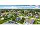 An aerial view shows houses in a neighborhood, many with green lawns, and solar panels at 716 Maderia Ct, Kissimmee, FL 34758