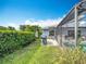 Lush backyard showcasing a grill, covered seating area, and screened-in pool, ideal for outdoor enjoyment at 716 Maderia Ct, Kissimmee, FL 34758