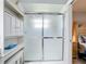 Bright bathroom featuring glass shower door and white shelving for toiletries and accessories at 716 Maderia Ct, Kissimmee, FL 34758