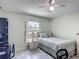 Cozy bedroom featuring a ceiling fan, a comfortable bed and a large window for natural light at 716 Maderia Ct, Kissimmee, FL 34758