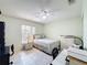 Bright bedroom featuring a ceiling fan, tile flooring, and a view to the neighborhood outside at 716 Maderia Ct, Kissimmee, FL 34758