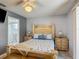 Bright bedroom featuring a decorative wood bed frame and a door that leads to the bathroom at 716 Maderia Ct, Kissimmee, FL 34758