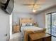 Well-lit bedroom featuring a decorative wood bed, bedside tables, and sliding door to the patio at 716 Maderia Ct, Kissimmee, FL 34758