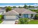 Exterior of single-story home featuring a well-maintained lawn, attached garage, and covered front porch at 716 Maderia Ct, Kissimmee, FL 34758