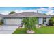 Lovely single-story home featuring a two-car garage, manicured lawn, and mature palm trees at 716 Maderia Ct, Kissimmee, FL 34758