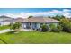 Charming single-story home featuring a lush green lawn, manicured garden beds, and a welcoming front porch seating area at 716 Maderia Ct, Kissimmee, FL 34758