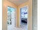 Hallway view features a bathroom and bedroom with neutral tones, tile flooring, and white closet at 716 Maderia Ct, Kissimmee, FL 34758