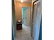 Hallway featuring tiled floors, an office setup and an open bathroom door at 716 Maderia Ct, Kissimmee, FL 34758