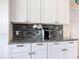 Well-lit kitchen featuring white cabinets, granite counters and modern backsplash at 716 Maderia Ct, Kissimmee, FL 34758