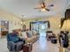 Comfortable living room with a ceiling fan, plush seating, and access to the screened pool area at 716 Maderia Ct, Kissimmee, FL 34758