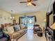 Living room features a ceiling fan, comfortable seating, and a view of the dining area and pool at 716 Maderia Ct, Kissimmee, FL 34758