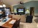 Open-concept living and dining area, featuring a TV and a sliding door to the backyard at 716 Maderia Ct, Kissimmee, FL 34758