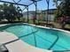 Backyard pool with a screened enclosure surrounded by landscaping at 716 Maderia Ct, Kissimmee, FL 34758
