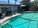 Inviting pool area with ample seating, umbrella and a screened enclosure at 716 Maderia Ct, Kissimmee, FL 34758