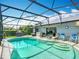 Inviting screened-in pool area surrounded by lush landscaping, outdoor furniture, and built-in bar at 716 Maderia Ct, Kissimmee, FL 34758