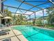 Relax in this beautiful screened-in pool surrounded by lush landscaping, perfect for entertaining and enjoying the outdoors at 716 Maderia Ct, Kissimmee, FL 34758