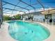 Relaxing screened-in pool area with lush landscaping, outdoor furniture, and built-in bar at 716 Maderia Ct, Kissimmee, FL 34758