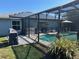 Screened pool features an outdoor cooking area and solar panels for energy efficiency at 716 Maderia Ct, Kissimmee, FL 34758