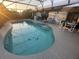 Screened-in pool with integrated steps and surrounding patio area and outdoor furniture at 716 Maderia Ct, Kissimmee, FL 34758