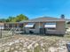 Exterior side view featuring the home's windows, awnings and AC unit surrounded by lush vegetation at 9019 Oakwood Dr, Lake Wales, FL 33898