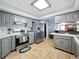 Well-lit kitchen featuring stainless steel appliances, grey cabinets and countertops and tile flooring at 9019 Oakwood Dr, Lake Wales, FL 33898