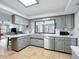 Well-lit kitchen featuring stainless steel appliances, grey cabinets and countertops and tile flooring at 9019 Oakwood Dr, Lake Wales, FL 33898