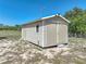 Exterior view of the property's shed, surrounded by a spacious yard and clear blue sky at 9019 Oakwood Dr, Lake Wales, FL 33898