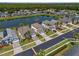 An aerial view shows a home next to a pond, palm trees, a road, and other homes in the community at 936 Lake Berkley Dr, Kissimmee, FL 34746