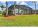 Scenic backyard features a large screened pool area and mature palm trees at 936 Lake Berkley Dr, Kissimmee, FL 34746