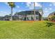 Backyard with an expansive screened-in pool and beautiful landscaping at 936 Lake Berkley Dr, Kissimmee, FL 34746