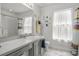 Bright bathroom featuring a large mirror and a shower with curtain at 936 Lake Berkley Dr, Kissimmee, FL 34746