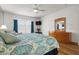 Comfortable bedroom featuring a wooden dresser, TV, and blue curtains at 936 Lake Berkley Dr, Kissimmee, FL 34746