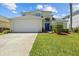 Charming two-story home featuring a well-manicured lawn and attached two-car garage on a sunny day at 936 Lake Berkley Dr, Kissimmee, FL 34746