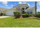 Charming two-story home with arched entryway, attached two car garage, and lush green lawn at 936 Lake Berkley Dr, Kissimmee, FL 34746