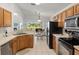 Open-concept kitchen with wood cabinets, black appliances, and breakfast nook overlooking a scenic lake at 936 Lake Berkley Dr, Kissimmee, FL 34746