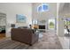 Open-concept living room with soaring ceilings, large windows, and cozy furnishings overlooking a serene view at 936 Lake Berkley Dr, Kissimmee, FL 34746