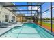 Screened in pool featuring beautiful blue tile and ample seating at 936 Lake Berkley Dr, Kissimmee, FL 34746