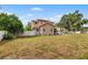 Spacious backyard with a view of the two-story home and neighboring detached structure at 102 Deen Blvd, Auburndale, FL 33823