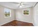 Bright bedroom with hardwood floors, two windows, a ceiling fan, and a closet at 102 Deen Blvd, Auburndale, FL 33823