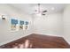 Primary bedroom with hardwood flooring, large windows, ceiling fan, and custom wall sconces at 102 Deen Blvd, Auburndale, FL 33823