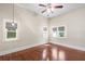 Spacious bedroom with a ceiling fan, windows with blinds, and gleaming hardwood floors at 102 Deen Blvd, Auburndale, FL 33823