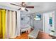 Comfortable bedroom with wood-look floors, a modern ceiling fan, and access to an ensuite bathroom at 102 Deen Blvd, Auburndale, FL 33823