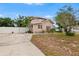 Charming home featuring a spacious driveway, manicured lawn, and a white privacy fence at 102 Deen Blvd, Auburndale, FL 33823