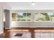 Sunroom with beautiful hardwood flooring and large windows showcasing the exterior landscape at 102 Deen Blvd, Auburndale, FL 33823
