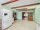 Open-concept kitchen with tiled floors, exposed beams, modern appliances, and access to multiple rooms at 1024 Campbell Ave, Lake Wales, FL 33853